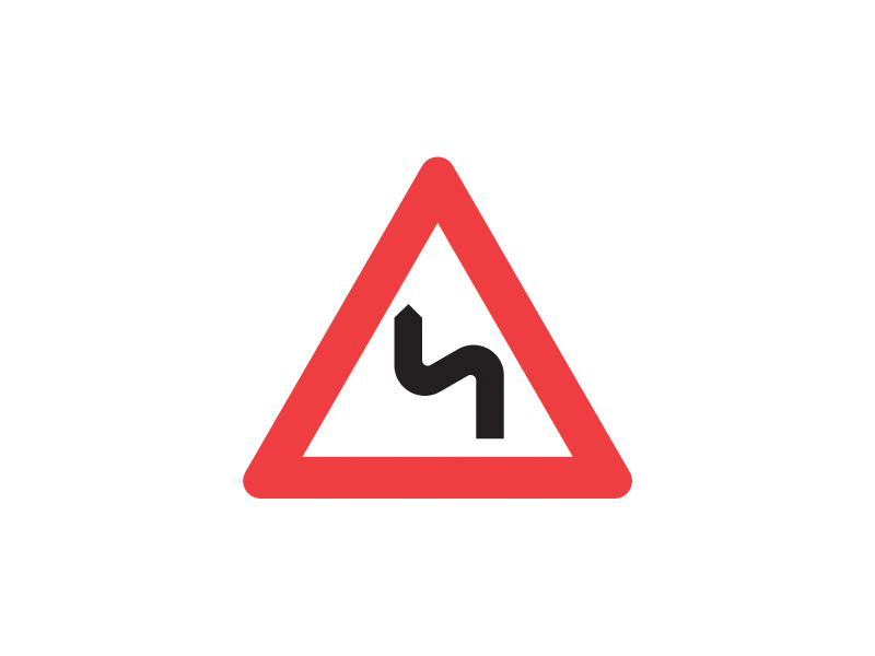 A42_2 - Flere sving, det første til venstre. Vær særlig opmærksom på vejens forløb. Tavlen angiver flere farlige, uoverskuelige vejsving det første til venstre.